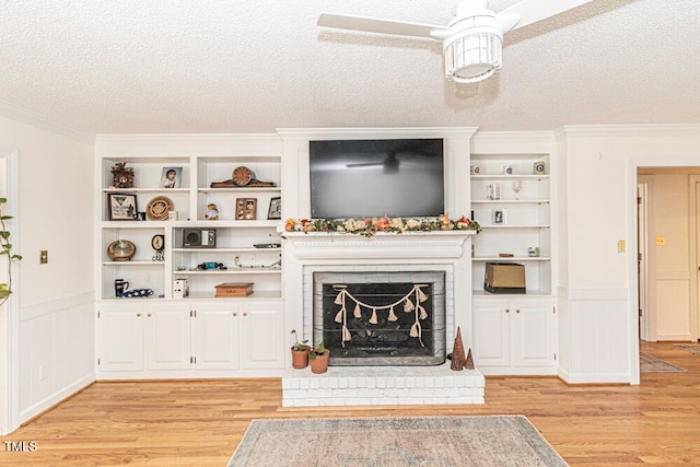 unfurnished living room featuring a fireplace, ceiling fan, a textured ceiling, and light hardwood / wood-style flooring