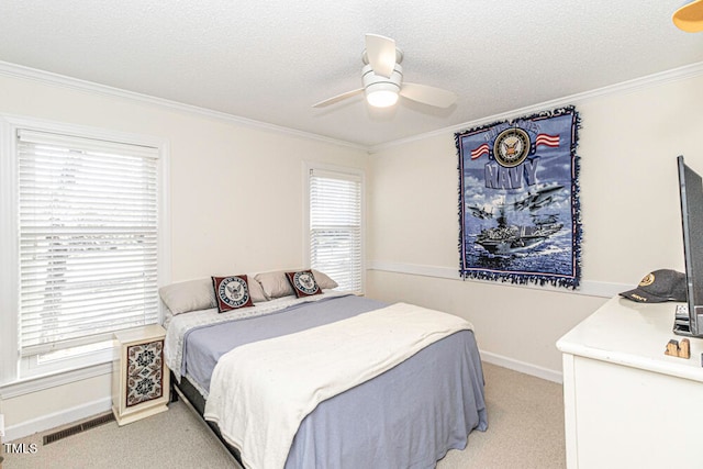 carpeted bedroom with a textured ceiling, ceiling fan, and crown molding