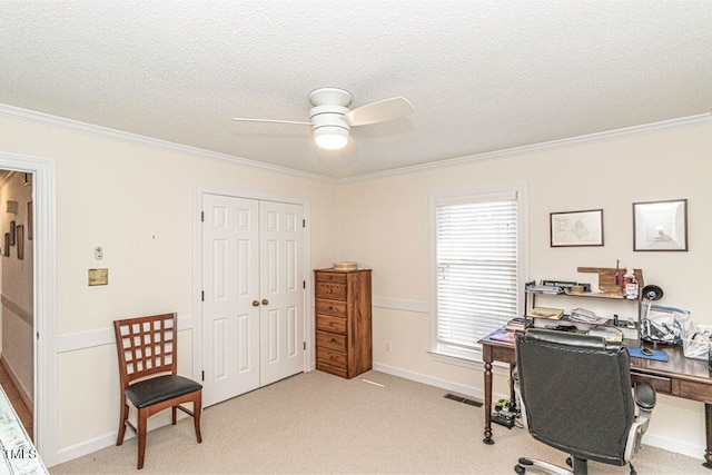 carpeted office space with ceiling fan, a healthy amount of sunlight, a textured ceiling, and ornamental molding