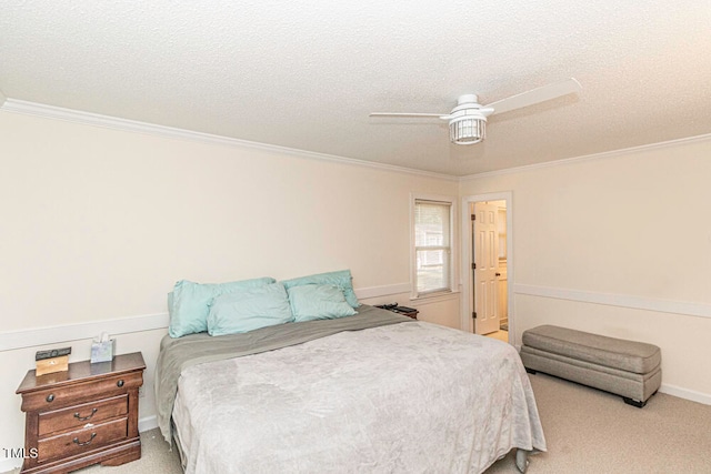 carpeted bedroom with a textured ceiling, ceiling fan, and crown molding