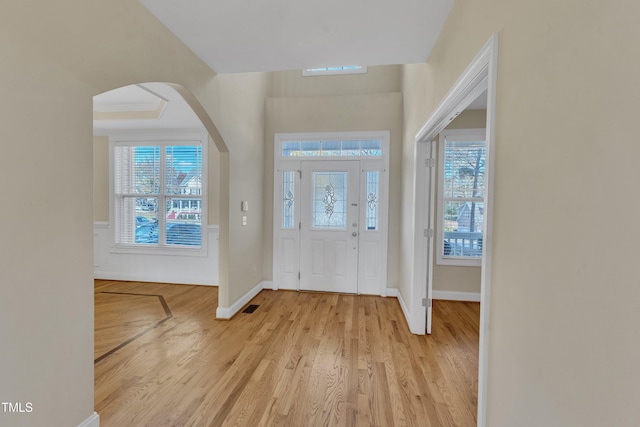 entryway with light hardwood / wood-style floors and crown molding