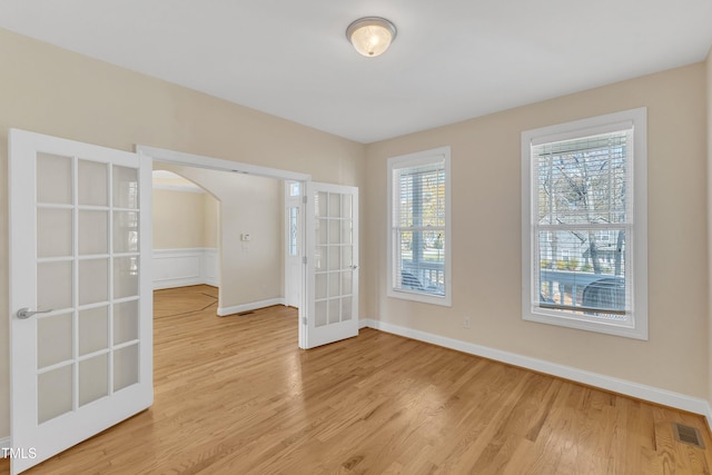 unfurnished room with light hardwood / wood-style floors and french doors