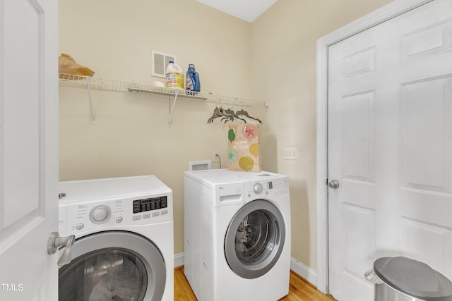 washroom with washer and dryer and light wood-type flooring