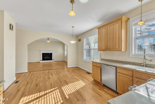 kitchen featuring hanging light fixtures, sink, stainless steel dishwasher, and light wood-type flooring