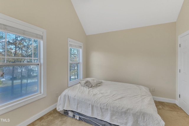 bedroom featuring light colored carpet and vaulted ceiling