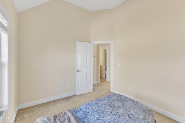 carpeted empty room featuring lofted ceiling