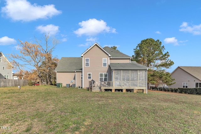 rear view of property featuring a lawn and a sunroom