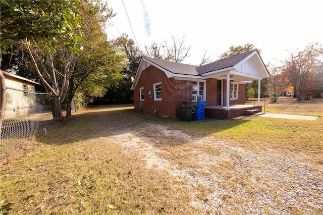 view of side of property featuring a yard and a porch