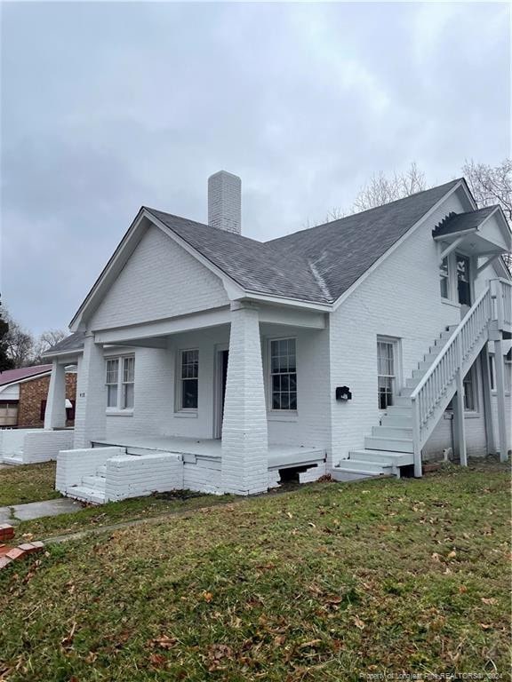 rear view of house featuring a yard