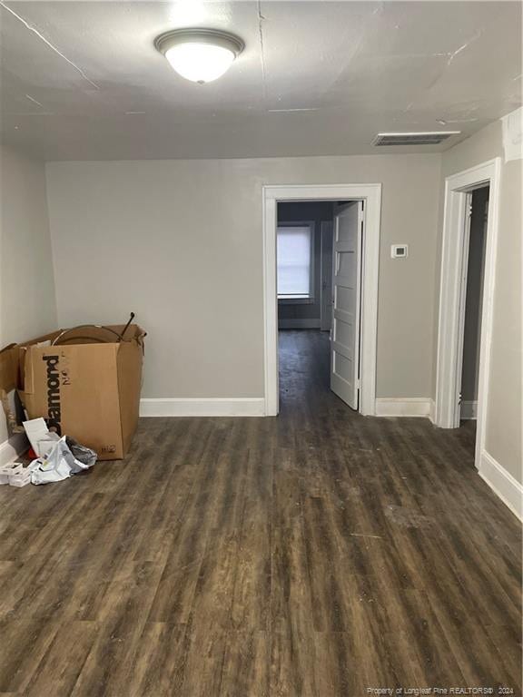 spare room featuring dark wood-type flooring