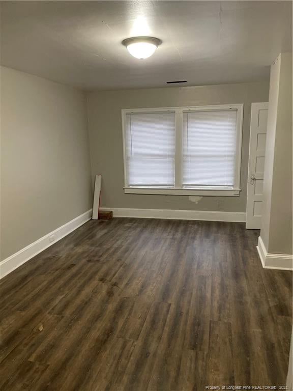 empty room with dark hardwood / wood-style flooring