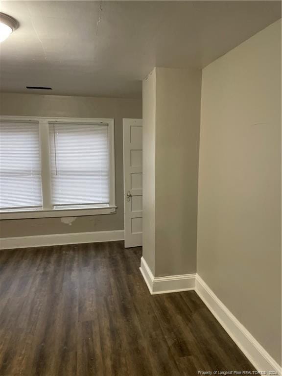 unfurnished room with dark hardwood / wood-style floors