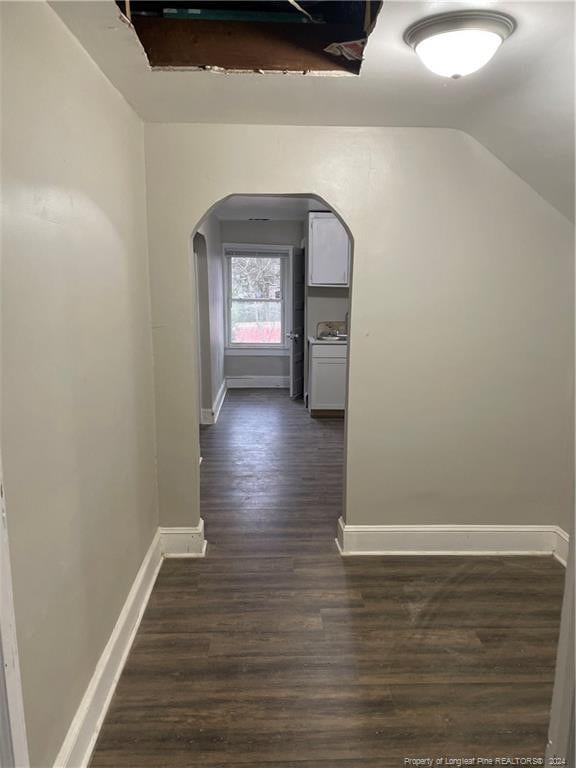 hall with dark hardwood / wood-style flooring and vaulted ceiling