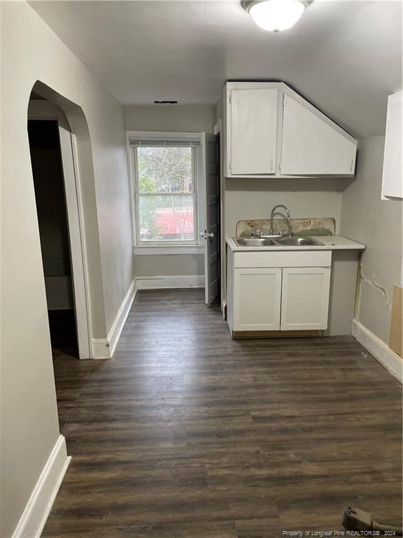 kitchen with white cabinets, sink, and dark wood-type flooring