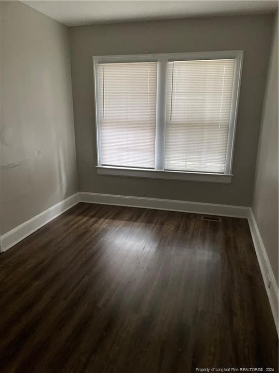 spare room featuring dark wood-type flooring