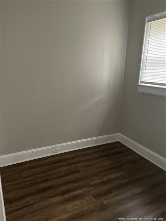 unfurnished room featuring dark wood-type flooring