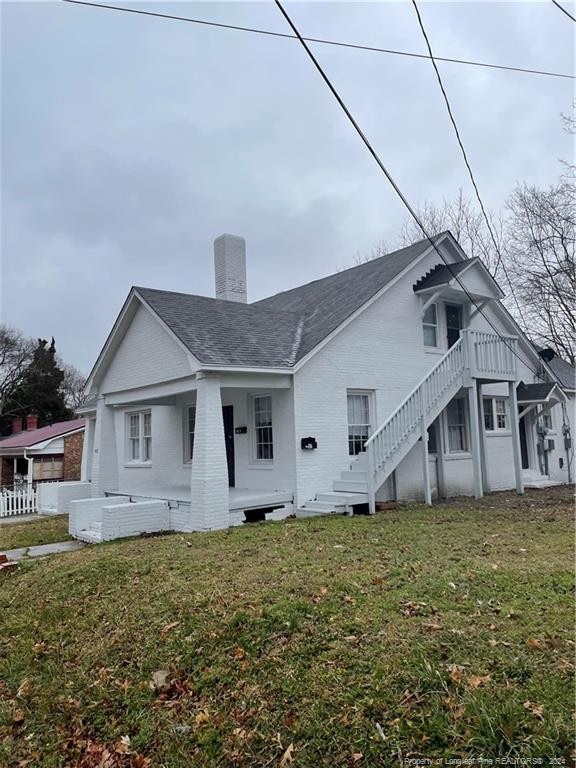 back of house featuring a lawn and a porch