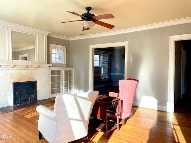 living room with ceiling fan, wood-type flooring, and ornamental molding