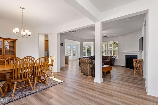 dining room featuring light hardwood / wood-style floors and ceiling fan with notable chandelier