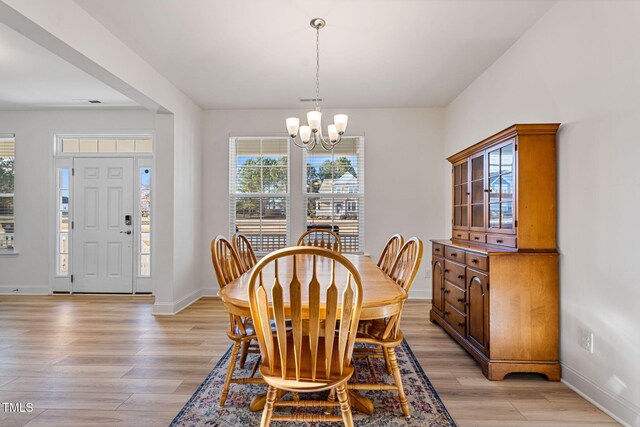 dining space featuring an inviting chandelier and light wood-type flooring