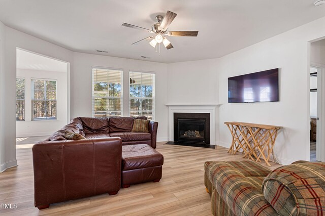 living room with ceiling fan and light hardwood / wood-style flooring