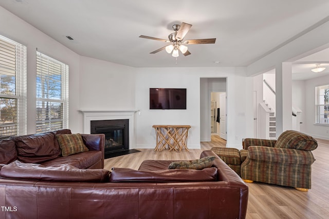 living room with ceiling fan and light hardwood / wood-style flooring