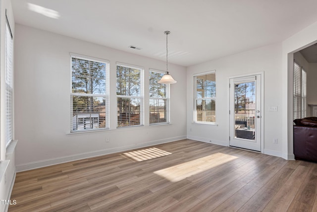 unfurnished dining area featuring hardwood / wood-style floors and plenty of natural light