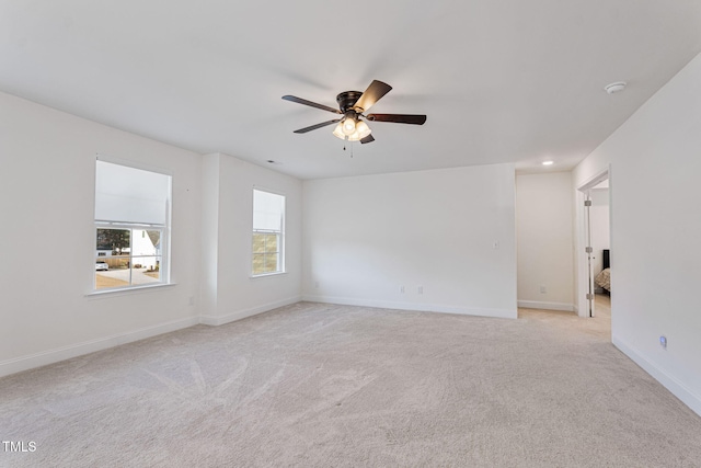 empty room featuring ceiling fan and light carpet