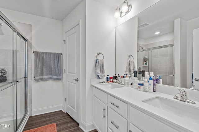 bathroom featuring hardwood / wood-style flooring, vanity, and a shower with shower door