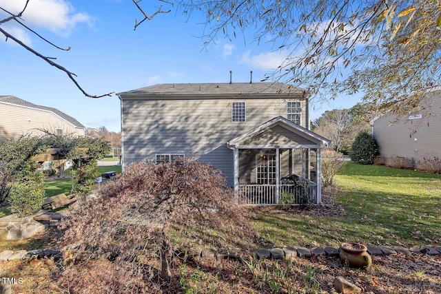 back of property featuring a sunroom and a lawn