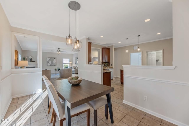 dining space featuring ceiling fan, light tile patterned floors, and crown molding