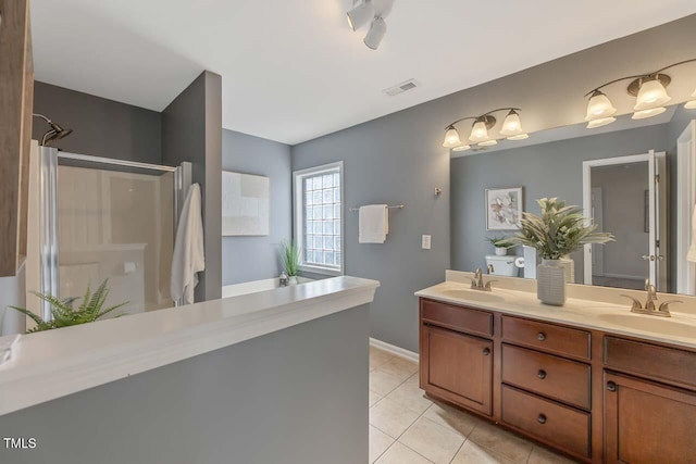 bathroom with tile patterned floors, vanity, and a shower with door