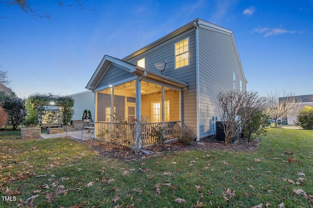 view of side of property with a yard, a patio, and a sunroom