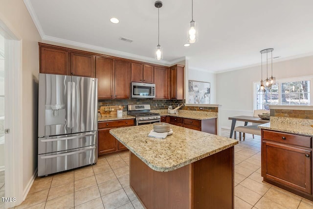 kitchen with ornamental molding, a center island, hanging light fixtures, and appliances with stainless steel finishes