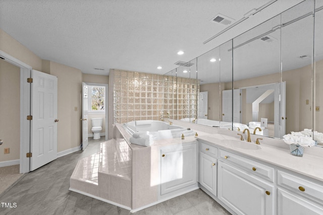 bathroom with toilet, a tub, a textured ceiling, and vanity