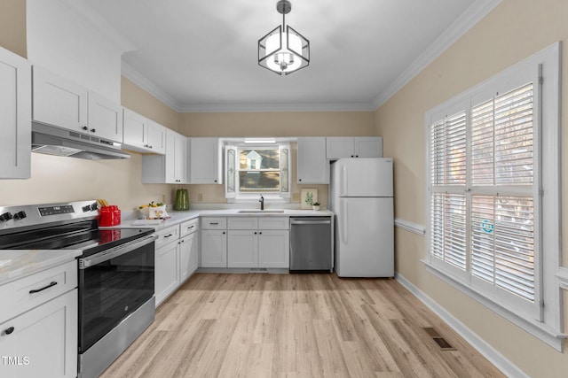 kitchen featuring appliances with stainless steel finishes, crown molding, sink, white cabinetry, and decorative light fixtures