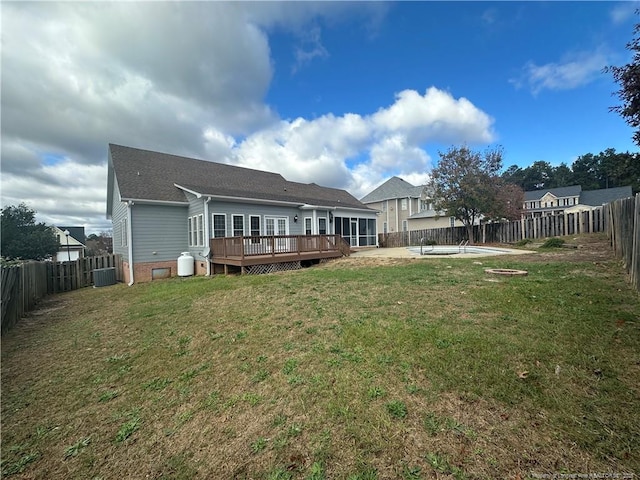 rear view of house featuring a swimming pool side deck, a yard, and central AC