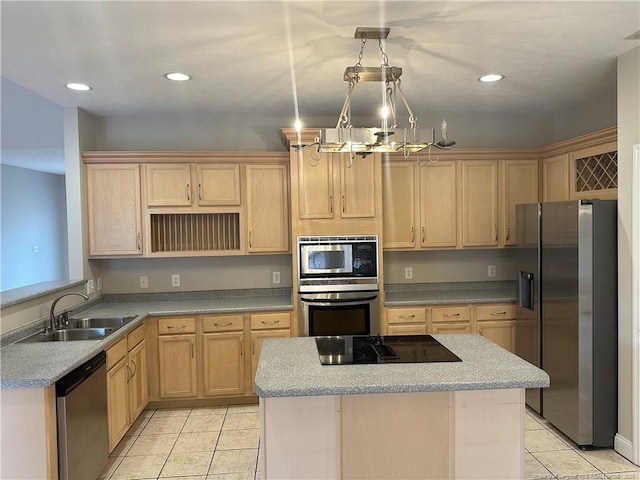 kitchen featuring appliances with stainless steel finishes, pendant lighting, light brown cabinetry, sink, and a center island