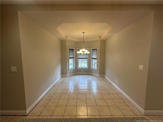 unfurnished dining area with an inviting chandelier, light tile patterned floors, and a tray ceiling