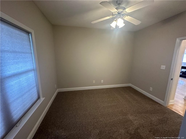 spare room with ceiling fan and carpet