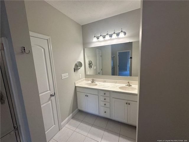 bathroom featuring vanity, tile patterned floors, and a textured ceiling