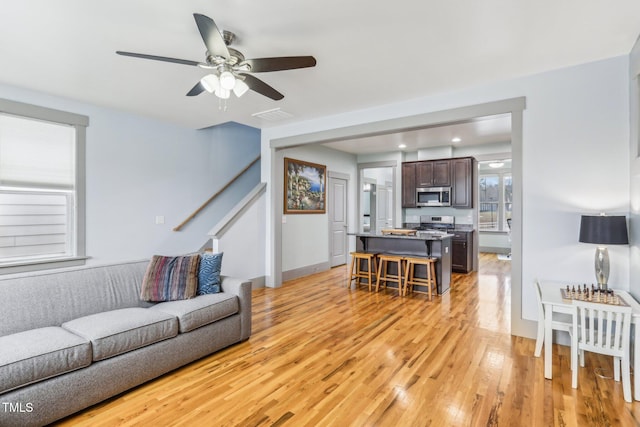 living room with ceiling fan and light hardwood / wood-style floors