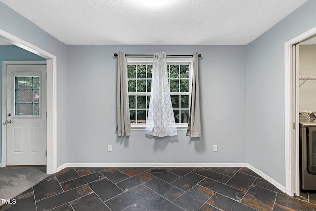 entrance foyer with washer / dryer, a textured ceiling, and plenty of natural light