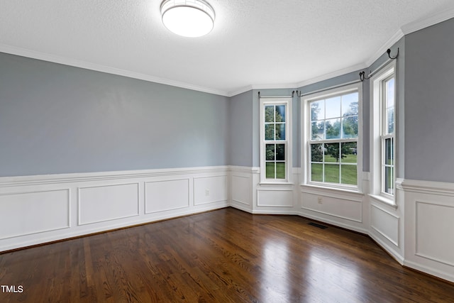 spare room featuring a textured ceiling, dark hardwood / wood-style floors, and ornamental molding