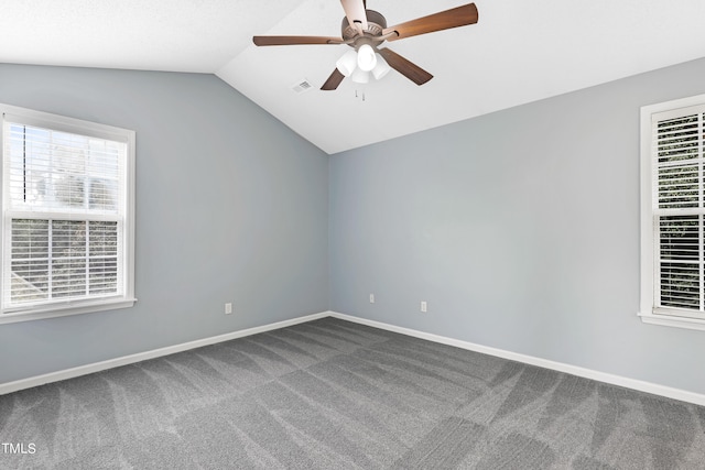 empty room with carpet, vaulted ceiling, plenty of natural light, and ceiling fan