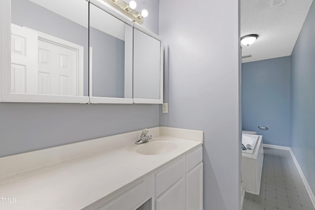 bathroom featuring tile patterned flooring, vanity, and a textured ceiling