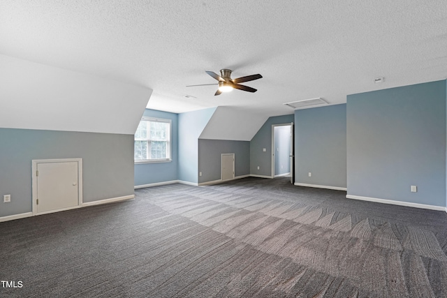 bonus room with ceiling fan, dark carpet, a textured ceiling, and vaulted ceiling