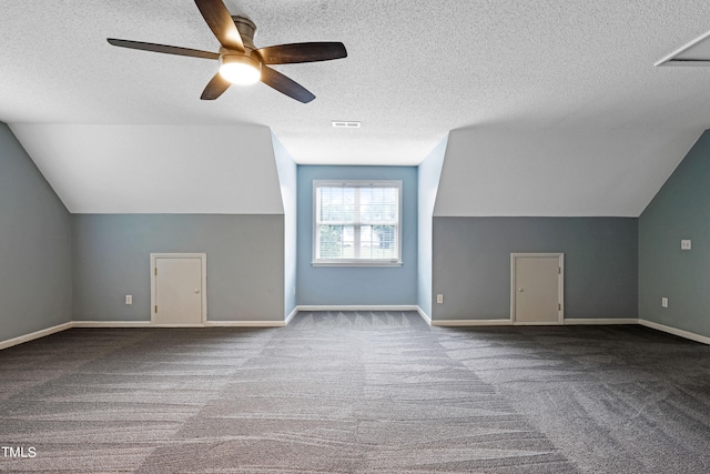 additional living space with a textured ceiling, ceiling fan, carpet floors, and lofted ceiling