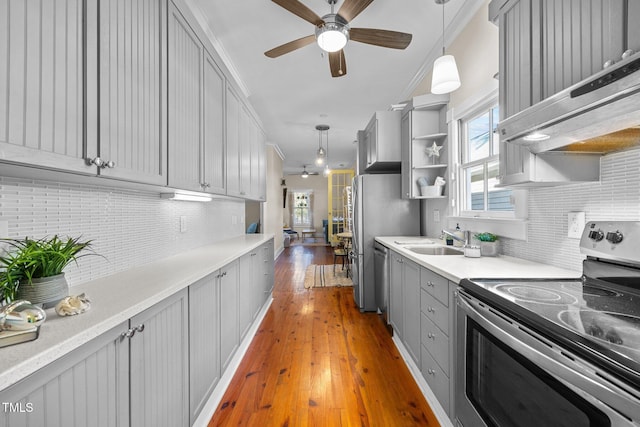 kitchen featuring pendant lighting, gray cabinetry, wood-type flooring, and stainless steel appliances