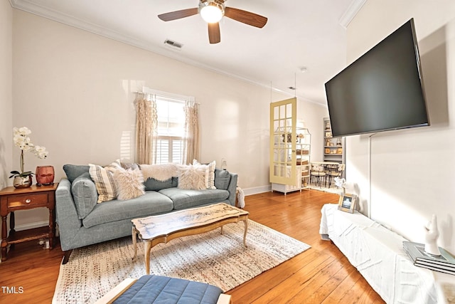 living room featuring light hardwood / wood-style floors, ceiling fan, and ornamental molding